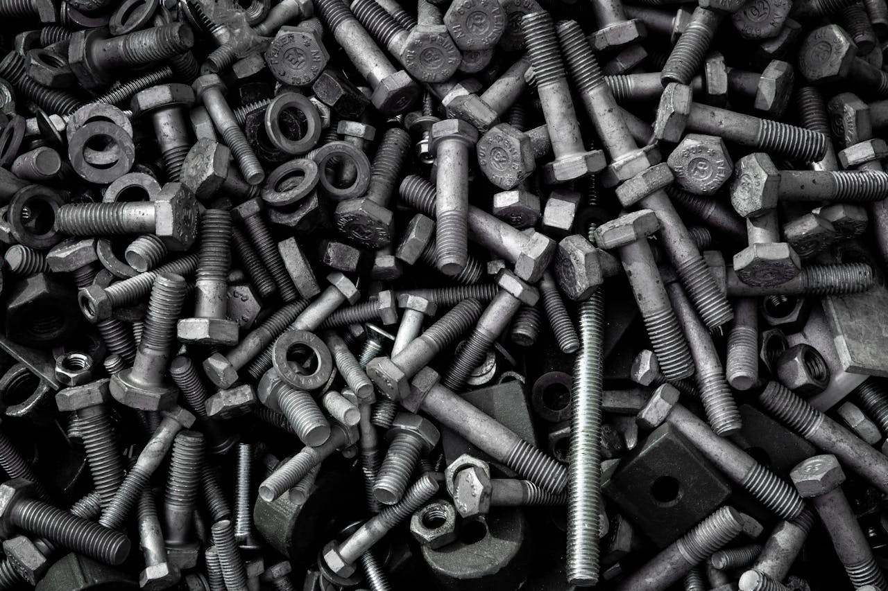 Detailed image of assorted industrial bolts and screws for recycling or mechanics.